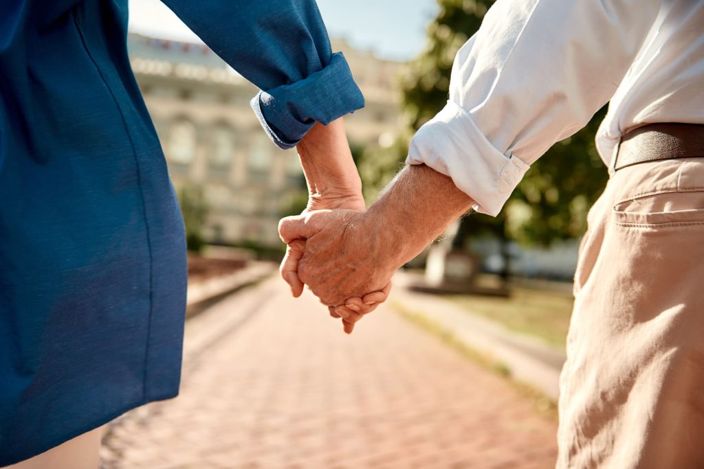 Couple de seniors se tenant la main, illustrant une assurance vie et la protection financière de ses proches.