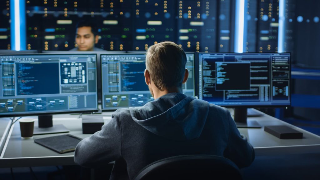 Expert en cybersécurité surveillant des systèmes informatiques, illustrant les assurances spécifiques pour les risques numériques et professionnels.