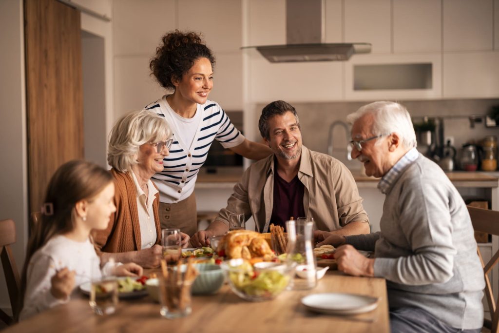 Famille réunie autour d'un repas à domicile, illustrant les assurances pour les particuliers.