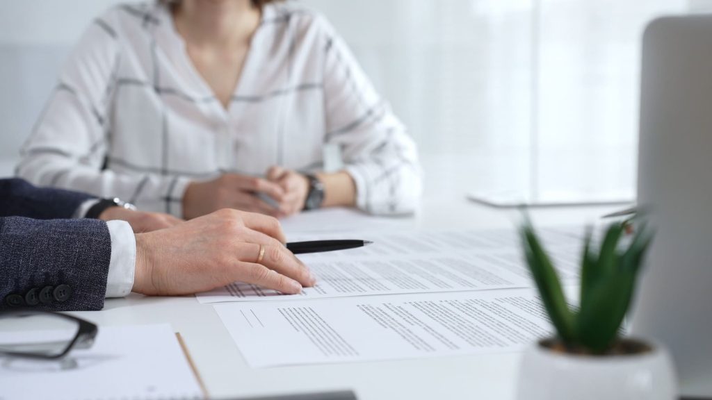 Courtier présentant un contrat d'assurance responsabilité civile professionnelle à un client.