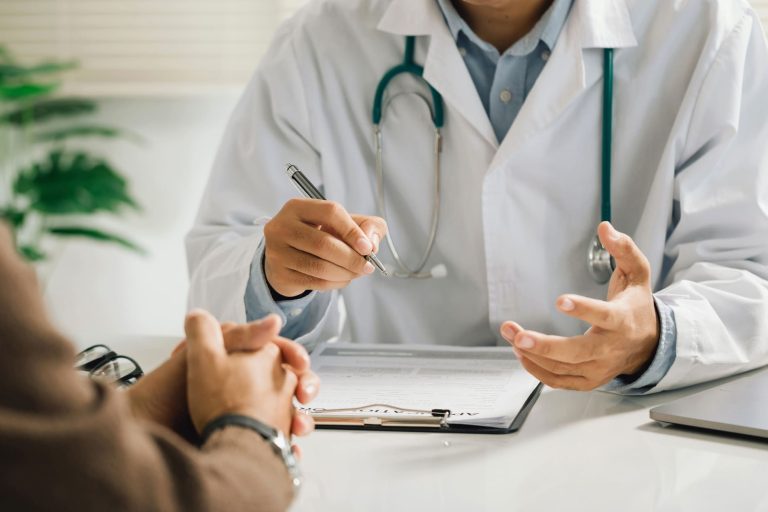 Médecin en consultation avec un patient, illustrant une assurance santé et hospitalisation.